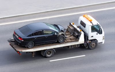 Wrecked car after an accident on a tow truck transported on a highway